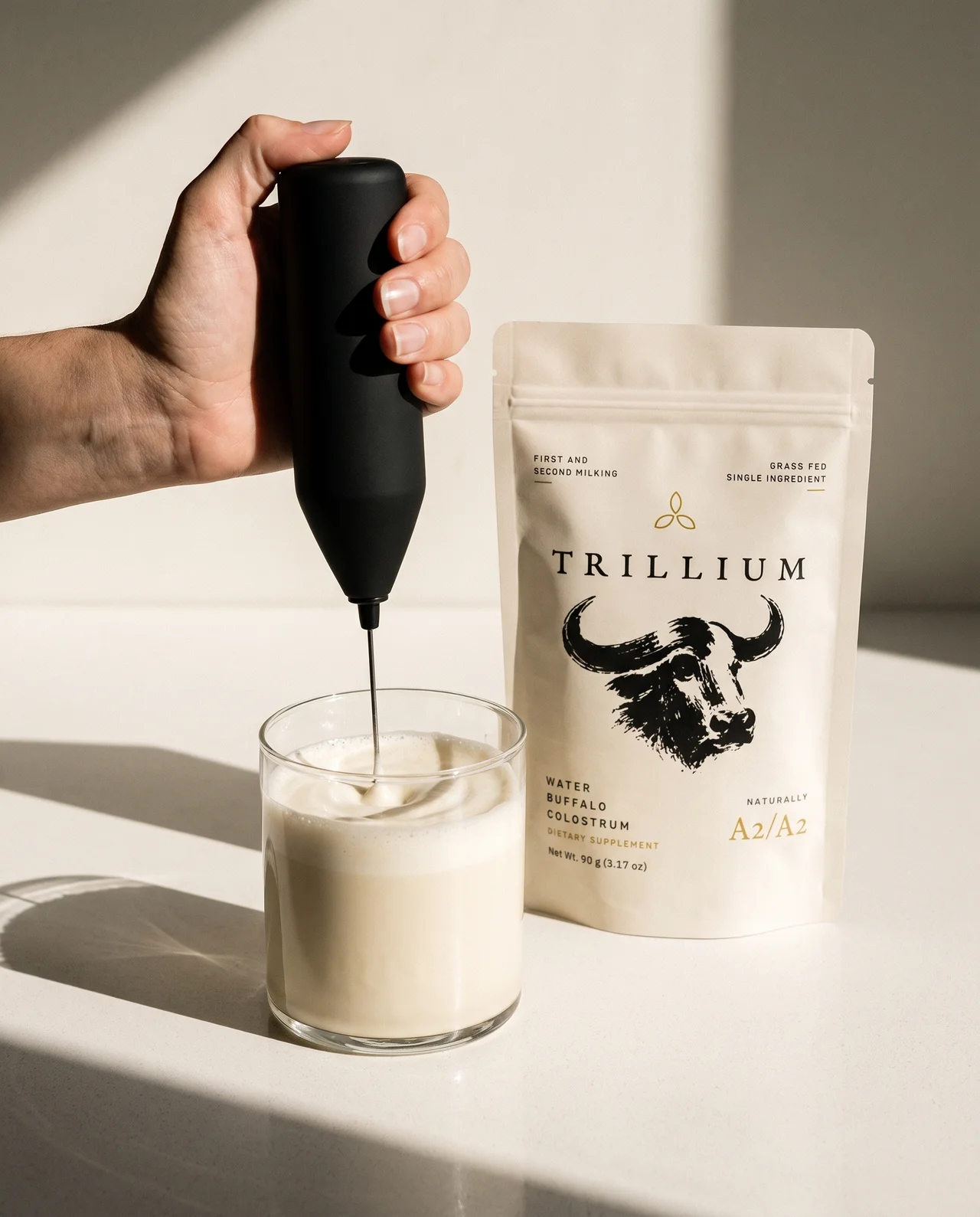 Trillium water buffalo colostrum beside a freshly frothed drink